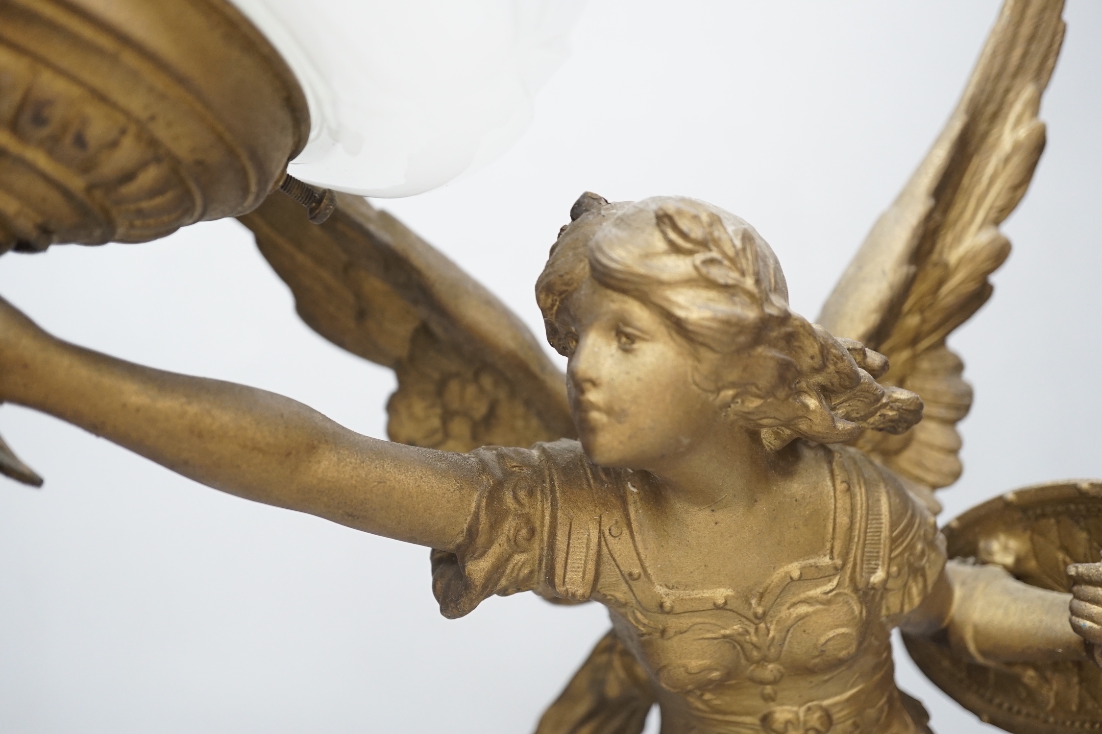 A gilt spelter Victory figural lamp with opaque glass shade, raised on a square base, 54cm high